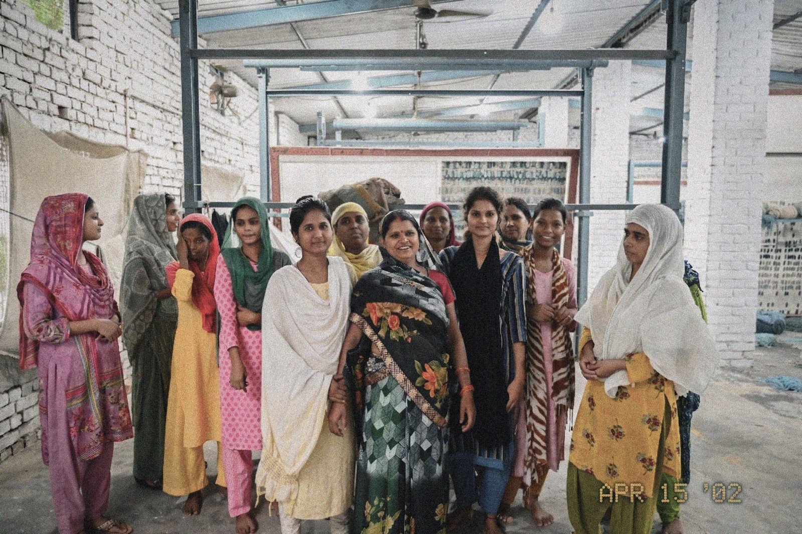 A group of women who work at the weaving unit standing together in the workshop